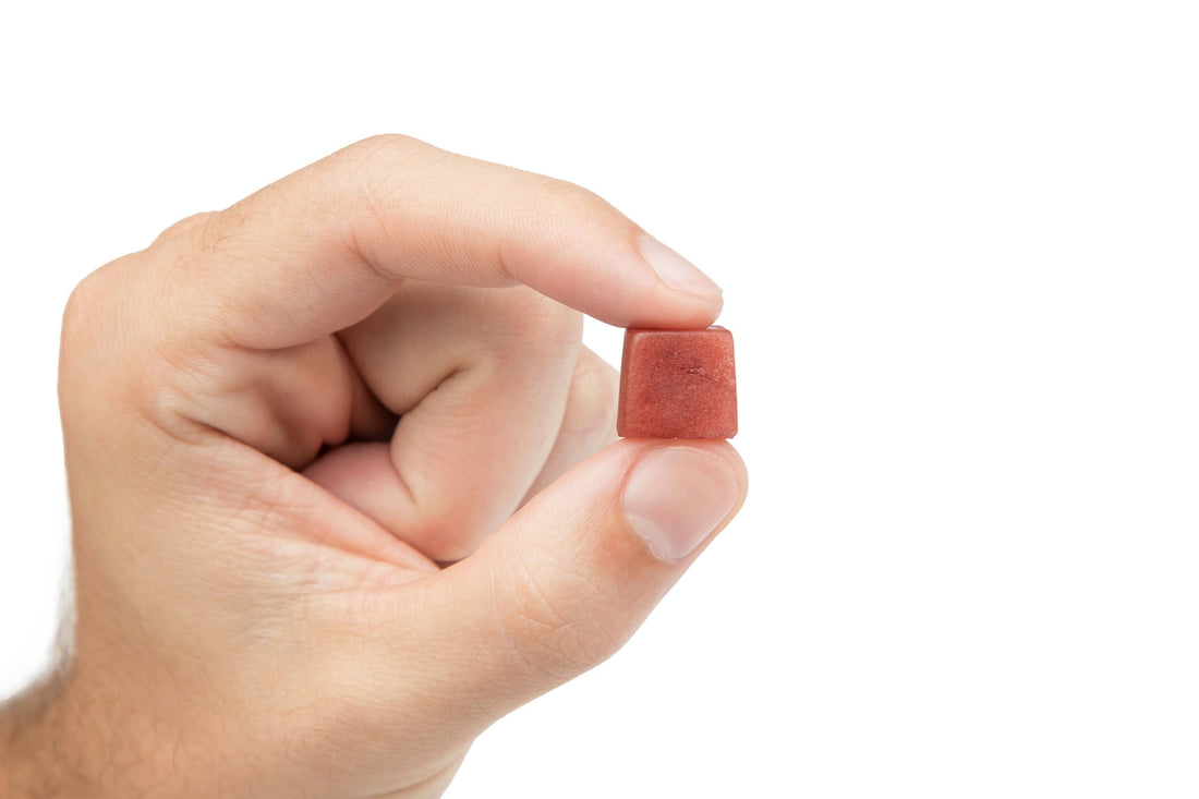 A strawberry Lion's Mane mushroom gummy held in hand
